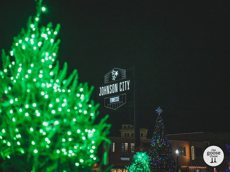 Green Christmas lights frame a Johnson City Tennessee sign at a past Jingle event